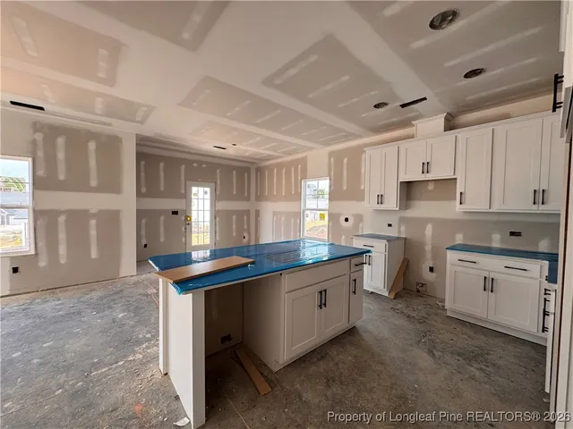 a kitchen with granite countertop a sink stove top oven and cabinets