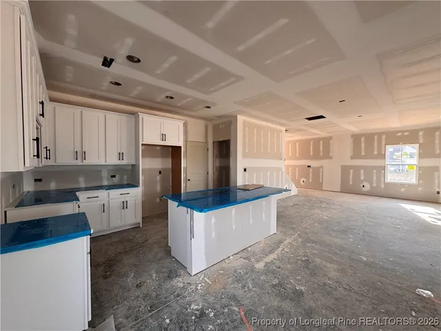 a kitchen with stainless steel appliances a white stove top oven a refrigerator a sink and white cabinets