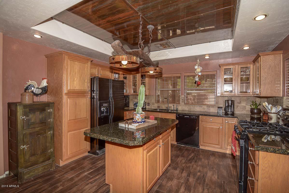 840 East Roberts Road Phoenix, AZ 85022 - Photo 19 of 52 a kitchen with stainless steel appliances granite countertop a sink stove and refrigerator