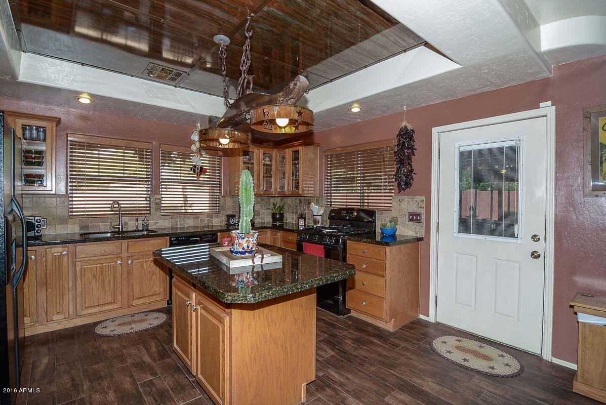 840 East Roberts Road Phoenix, AZ 85022 - Photo 20 of 52 a kitchen with stainless steel appliances granite countertop a sink stove and refrigerator