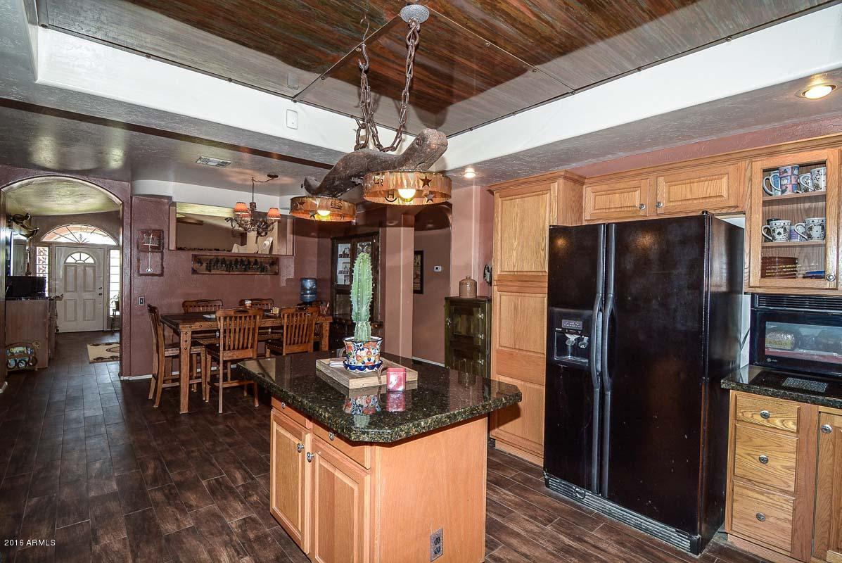 840 East Roberts Road Phoenix, AZ 85022 - Photo 21 of 52 a kitchen with stainless steel appliances granite countertop a refrigerator a stove and a dining table with wooden floor