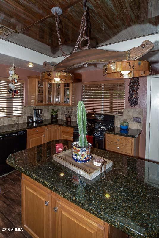 840 East Roberts Road Phoenix, AZ 85022 - Photo 24 of 52 a kitchen with kitchen island granite countertop a sink counter top space appliances and cabinets