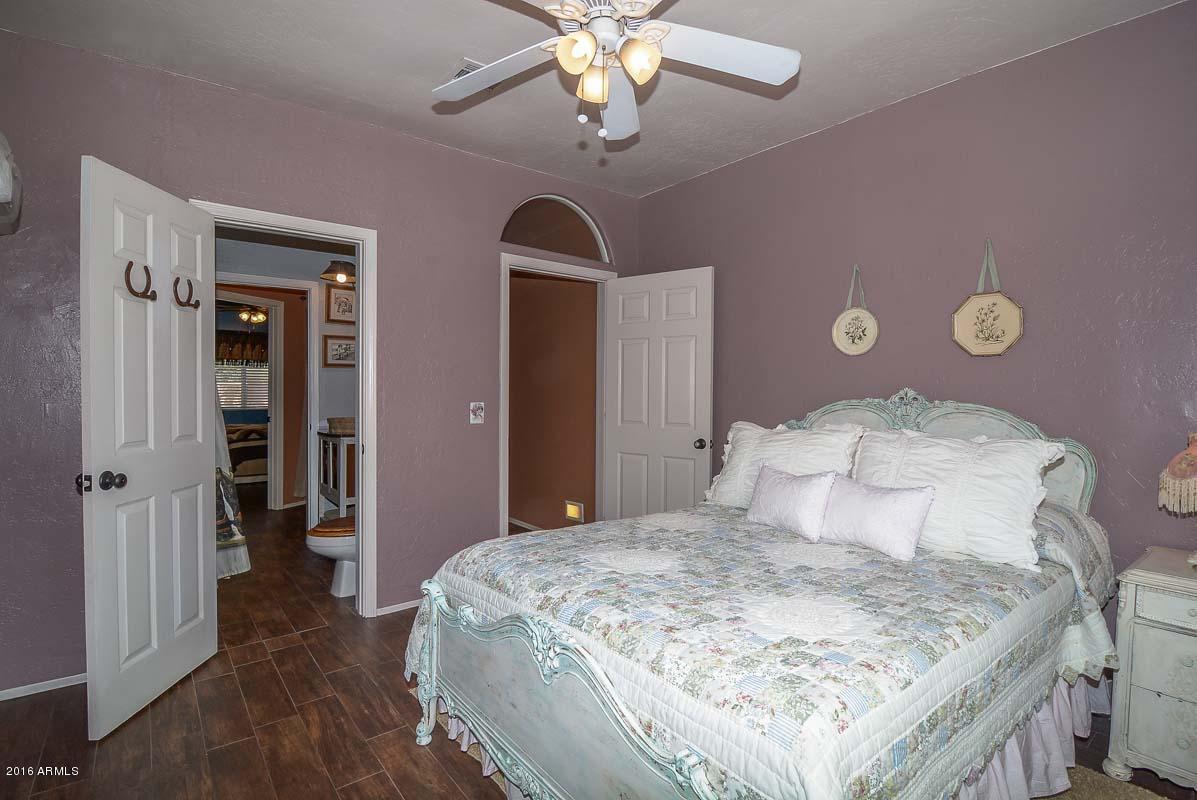 840 East Roberts Road Phoenix, AZ 85022 - Photo 37 of 52 a bedroom with a bed and a chandelier
