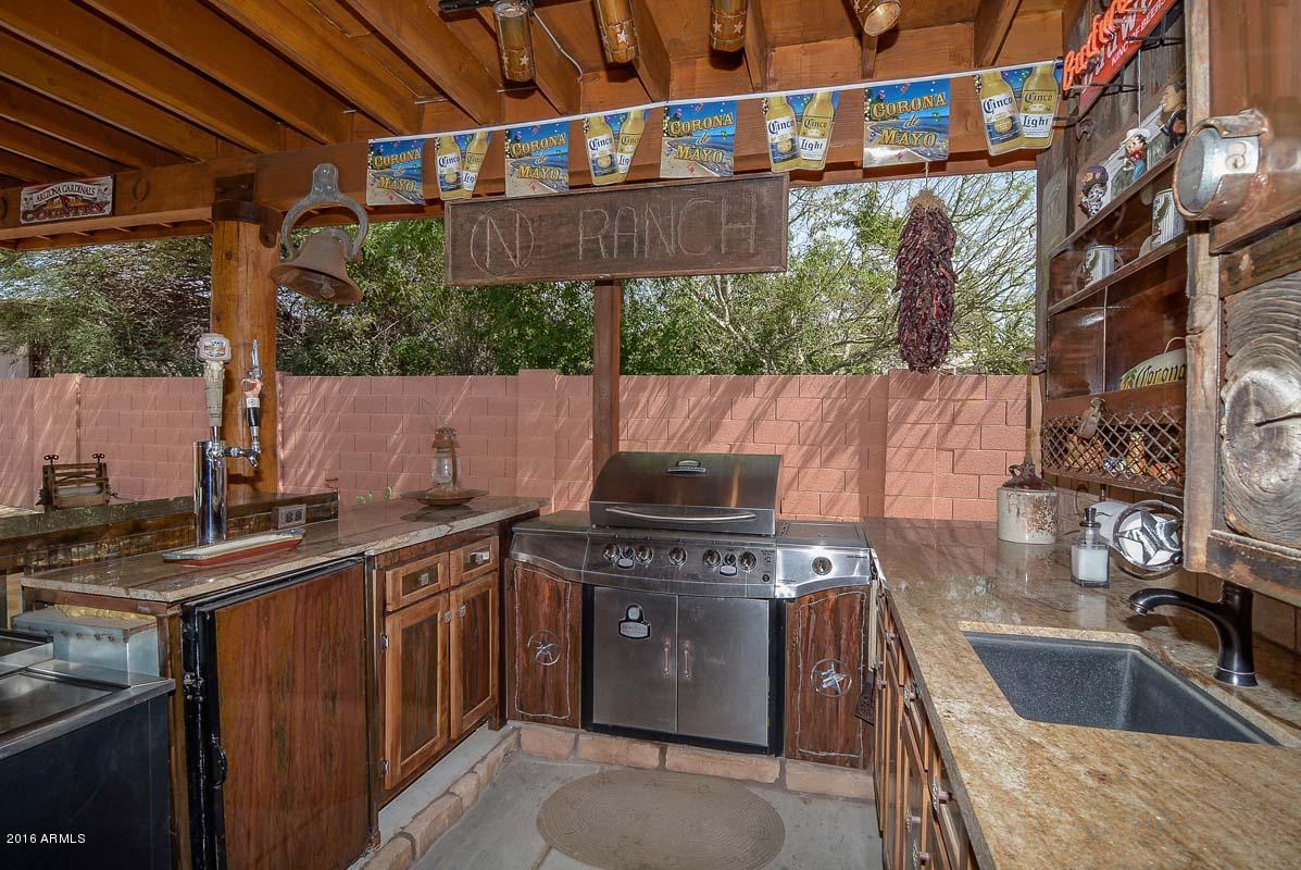 840 East Roberts Road Phoenix, AZ 85022 - Photo 43 of 52 a view of a kitchen with a sink and wooden cabinets
