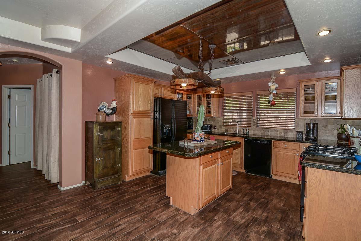 840 East Roberts Road Phoenix, AZ 85022 - Photo 5 of 52 a kitchen with granite countertop a stove and a refrigerator