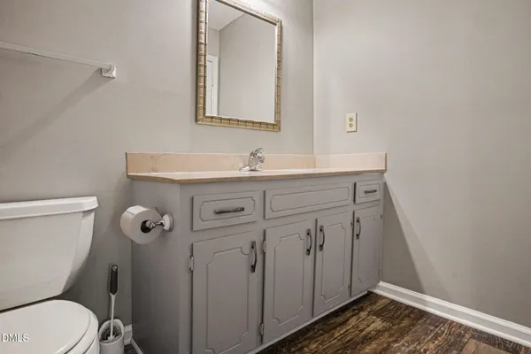 a bathroom with a granite countertop toilet sink and mirror