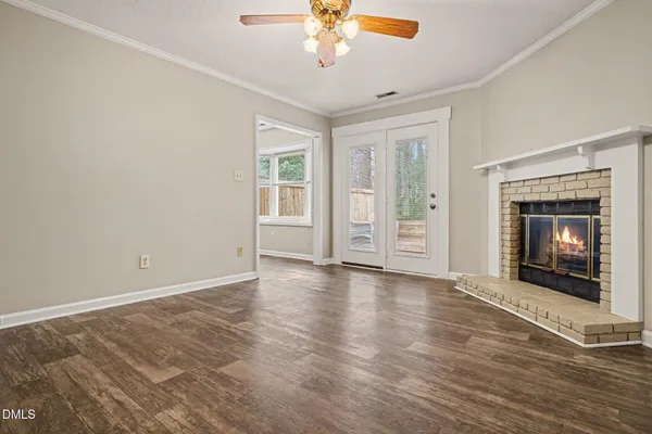 a view of an empty room with a fireplace and a window
