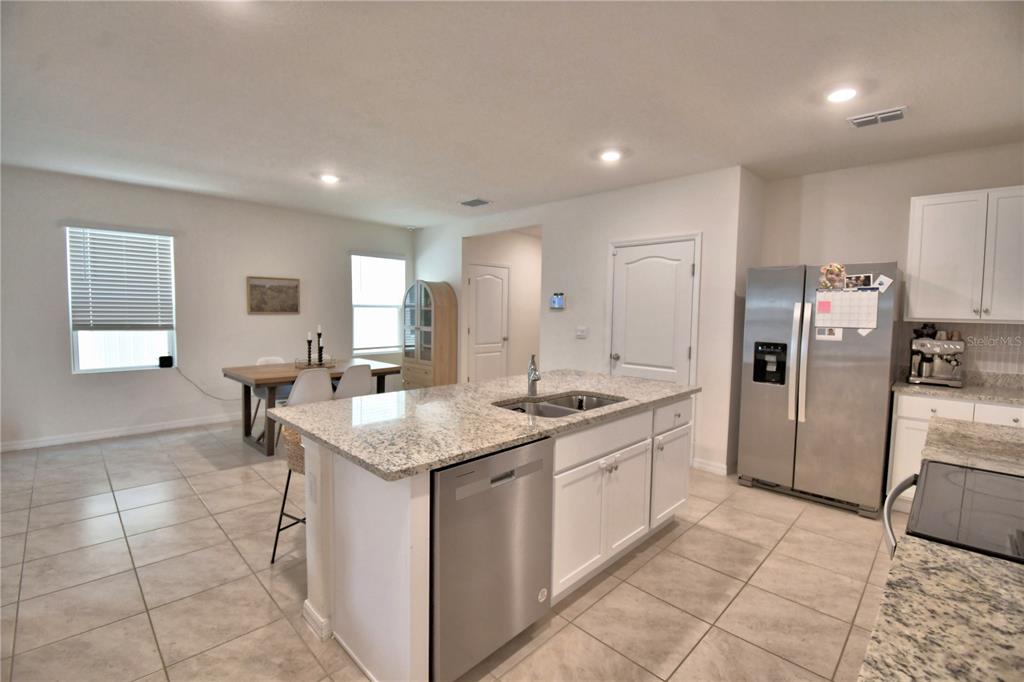 2839 Moulin Road Davenport, FL 33837 - Photo 17 of 75 a kitchen with a sink a counter top space and stainless steel appliances
