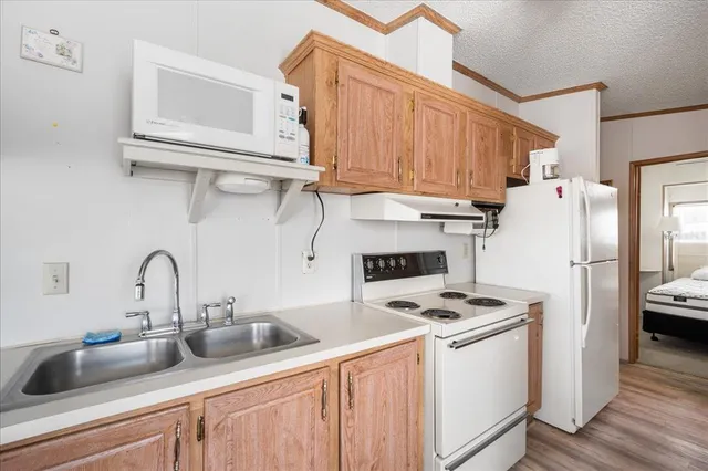 a kitchen with refrigerator a stove a sink and cabinets