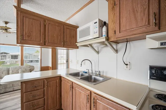 a kitchen with stainless steel appliances granite countertop a sink and cabinets with wooden floor