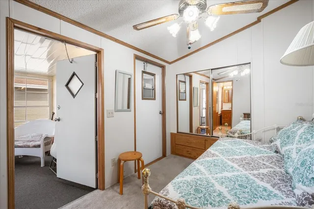 a spacious bedroom with a large bed and a chandelier