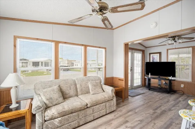 a living room with furniture a flat screen tv and a large window
