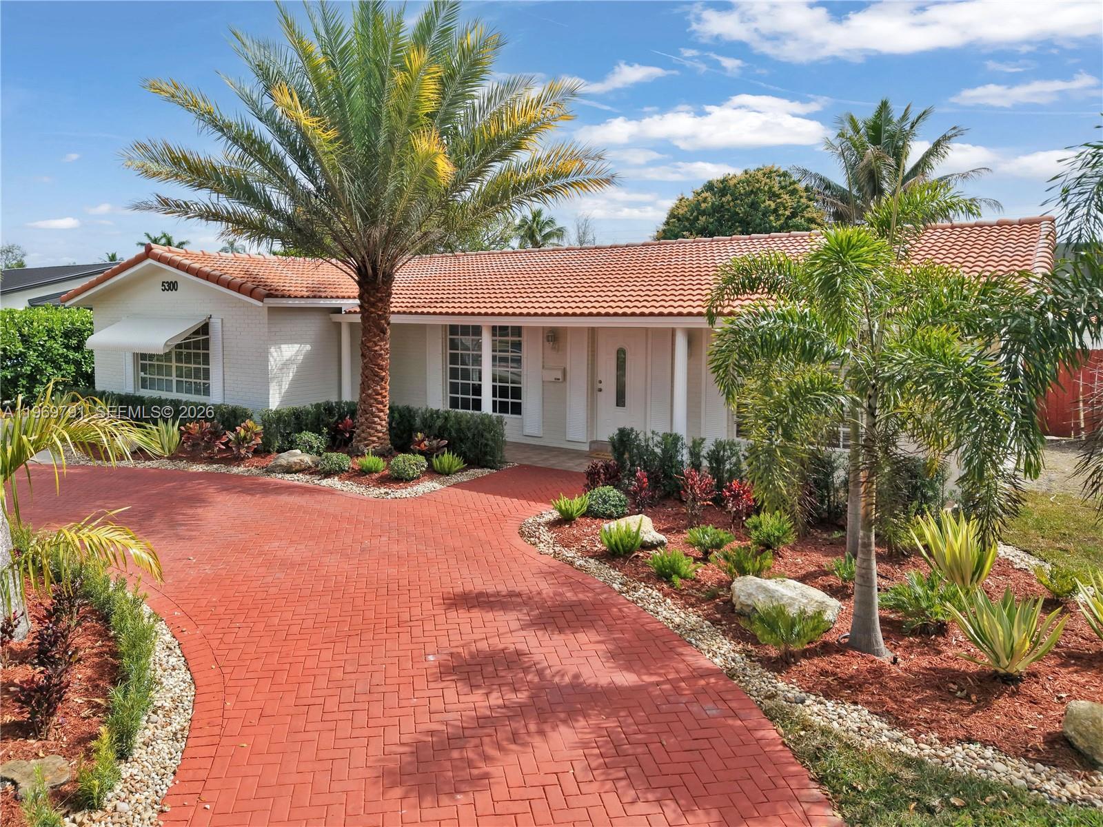a front view of a house with yard and green space