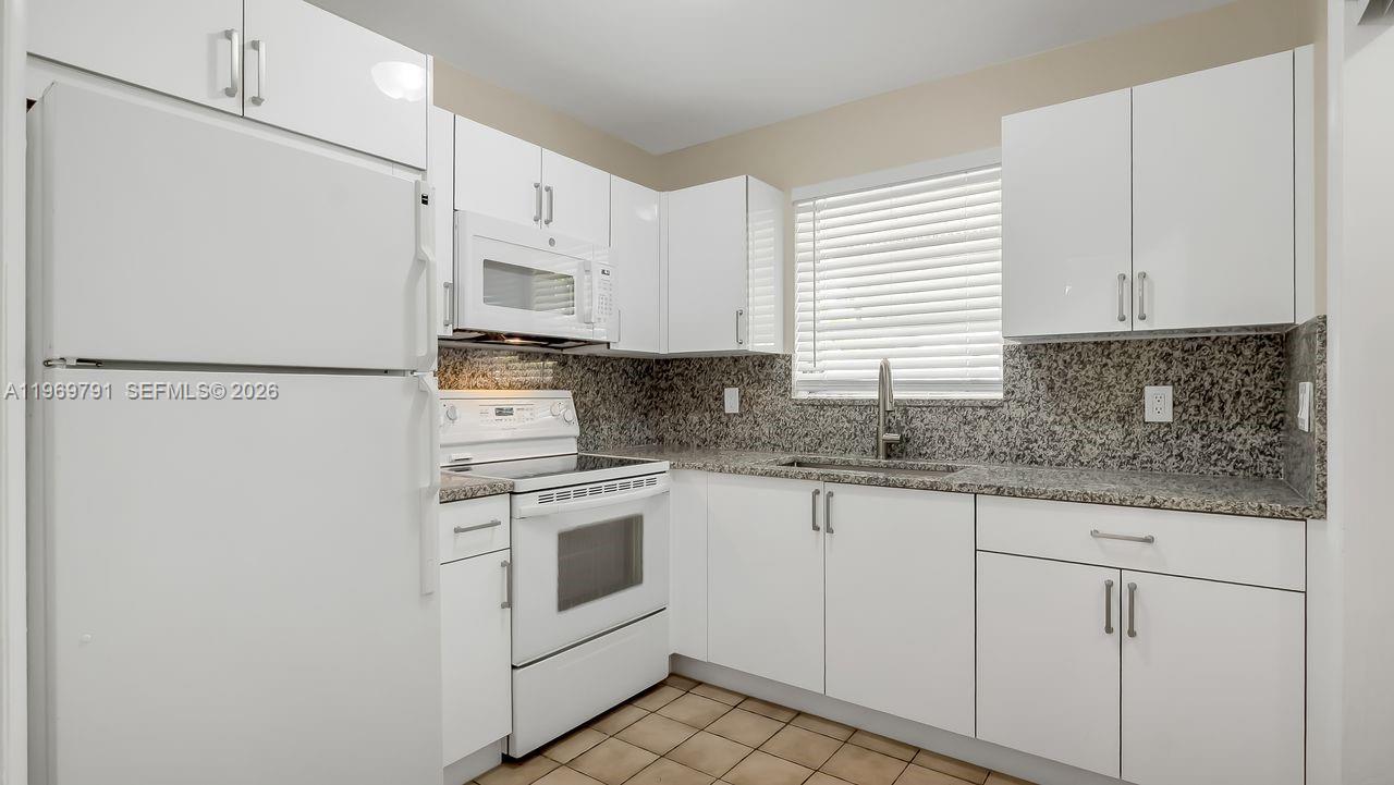 5300 Grant Street Hollywood, FL 33021 - Photo 35 of 46 a white kitchen with granite countertop stainless steel appliances