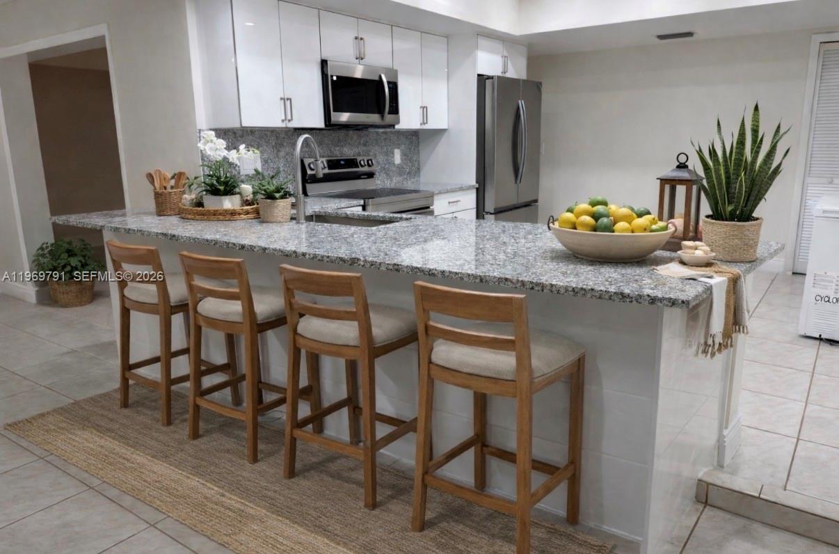 5300 Grant Street Hollywood, FL 33021 - Photo 4 of 46 a kitchen with granite countertop stainless steel appliances a sink stove and cabinets