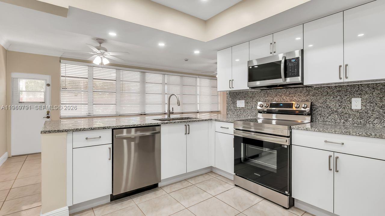 5300 Grant Street Hollywood, FL 33021 - Photo 8 of 46 a kitchen with stainless steel appliances granite countertop a sink and a stove