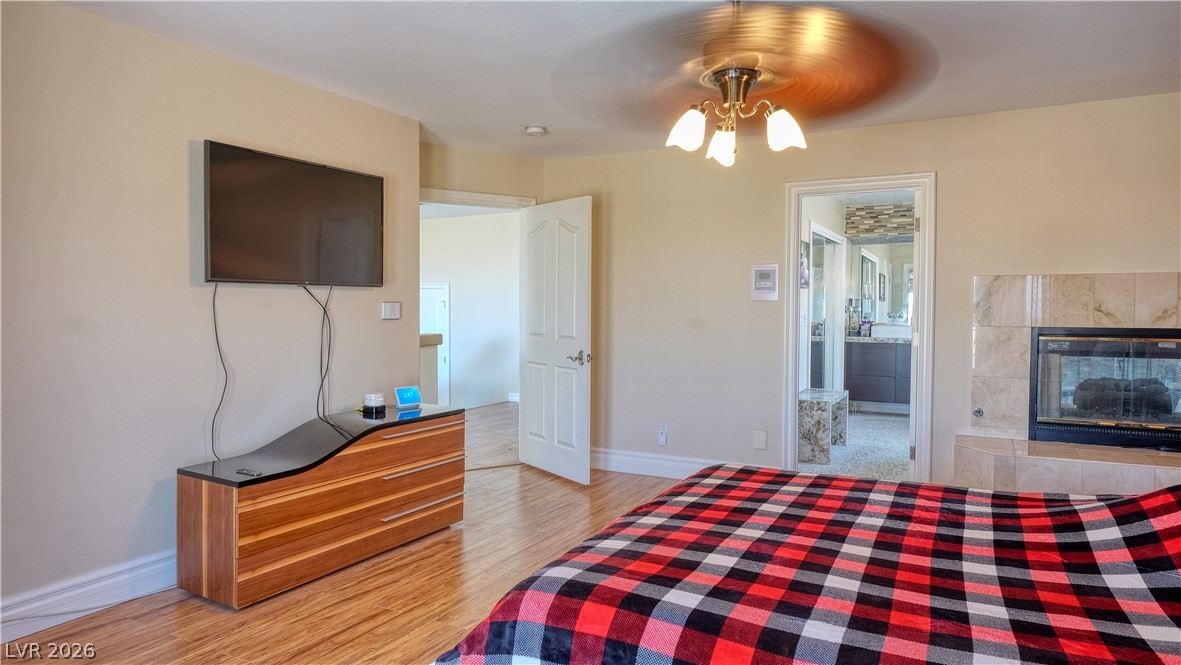 3704 North Campbell Road Las Vegas, NV 89129 - Photo 30 of 38 A comforting bedroom with warm wood floors and a charming fireplace feature.