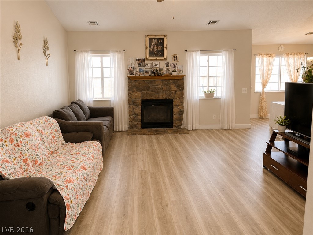 200 East Gamebird Road Pahrump, NV 89048 - Photo 3 of 23 A comforting fireplace hearth grounds this inviting living space with light wood-look flooring.