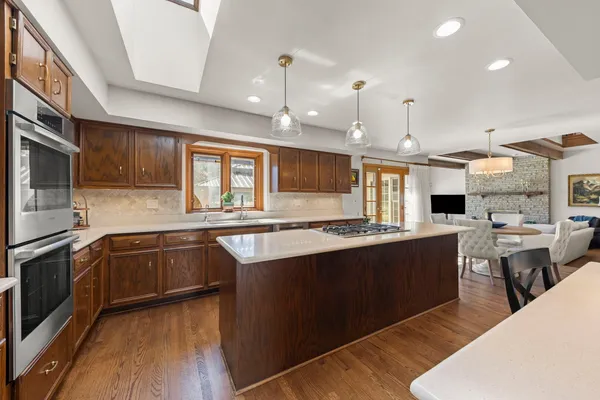 a large kitchen with stainless steel appliances granite countertop a stove and a sink