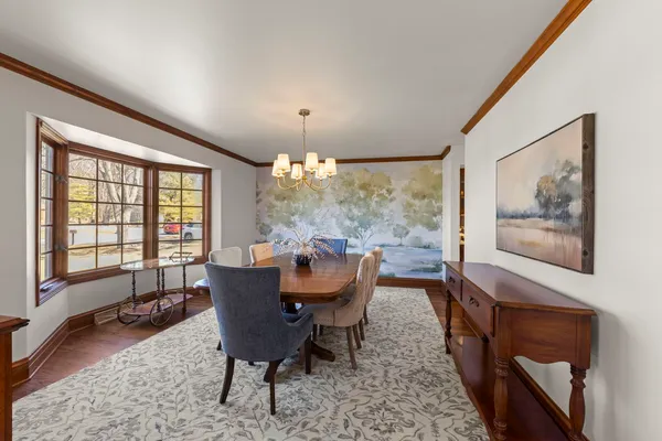 a dining room with furniture a chandelier and wooden floor