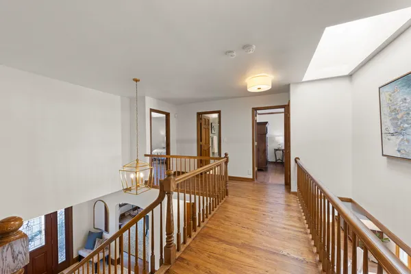 a view of a hallway with wooden floor and stairs
