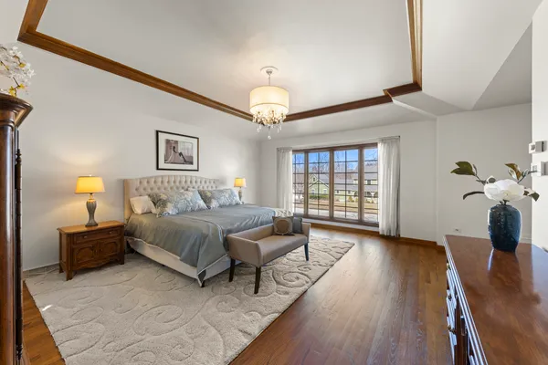 a spacious bedroom with a bed and a chandelier