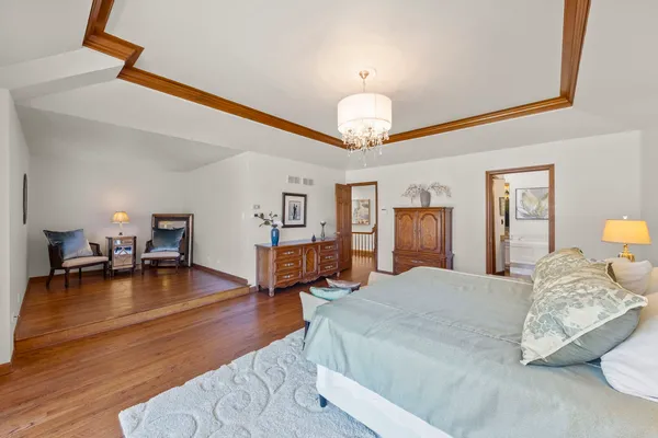 a spacious bedroom with a bed and a chandelier