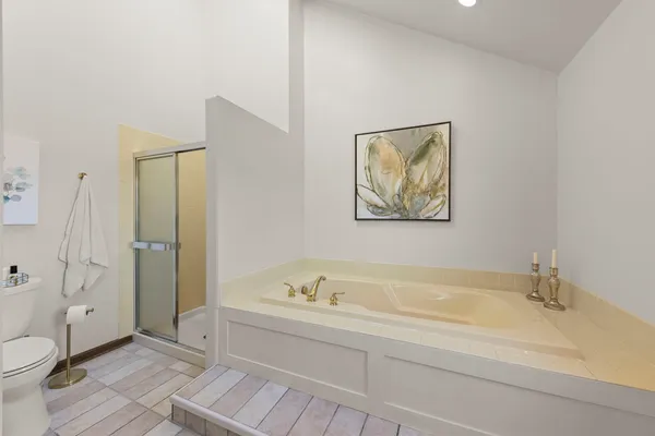 a spacious bathroom with a tub and toilet