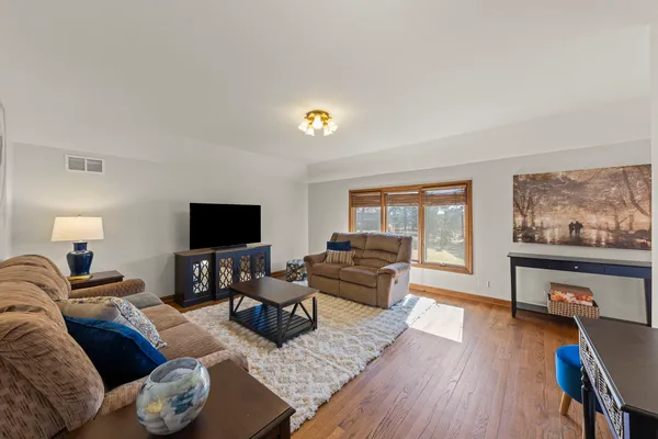 a living room with furniture and a flat screen tv with wooden floor