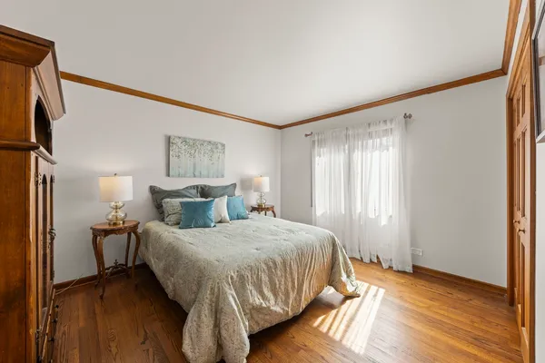 a bedroom with a bed lamp on table and a window