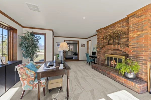 a living room with furniture a fireplace and large windows
