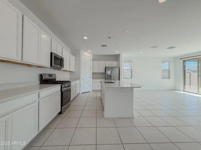 a large kitchen with stainless steel appliances granite countertop a stove and a sink