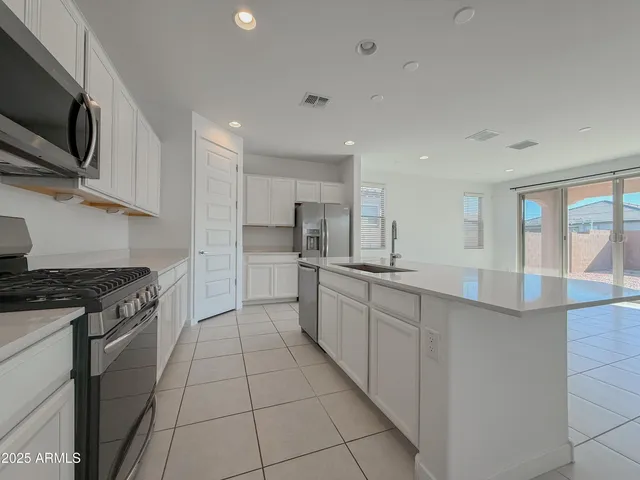 a kitchen with stainless steel appliances granite countertop a sink and dishwasher a stove top oven with wooden floor