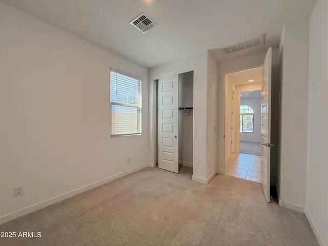 an empty room with closet and mirror