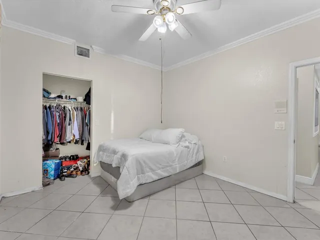 a bedroom with a bed and a ceiling fan