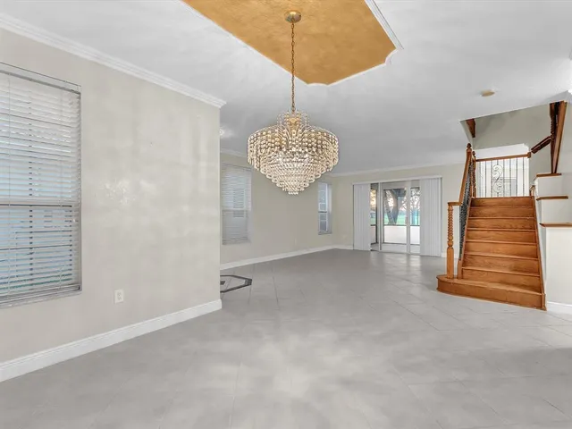 a view of kitchen with refrigerator and white cabinets