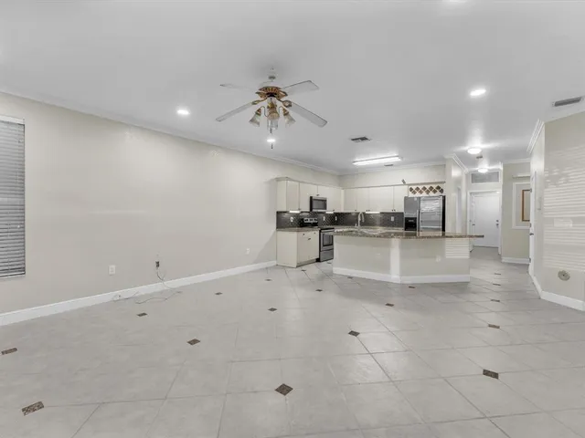 a kitchen with granite countertop a refrigerator and a stove top oven