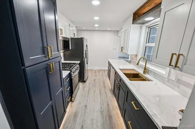 a kitchen with refrigerator a sink and wooden floor