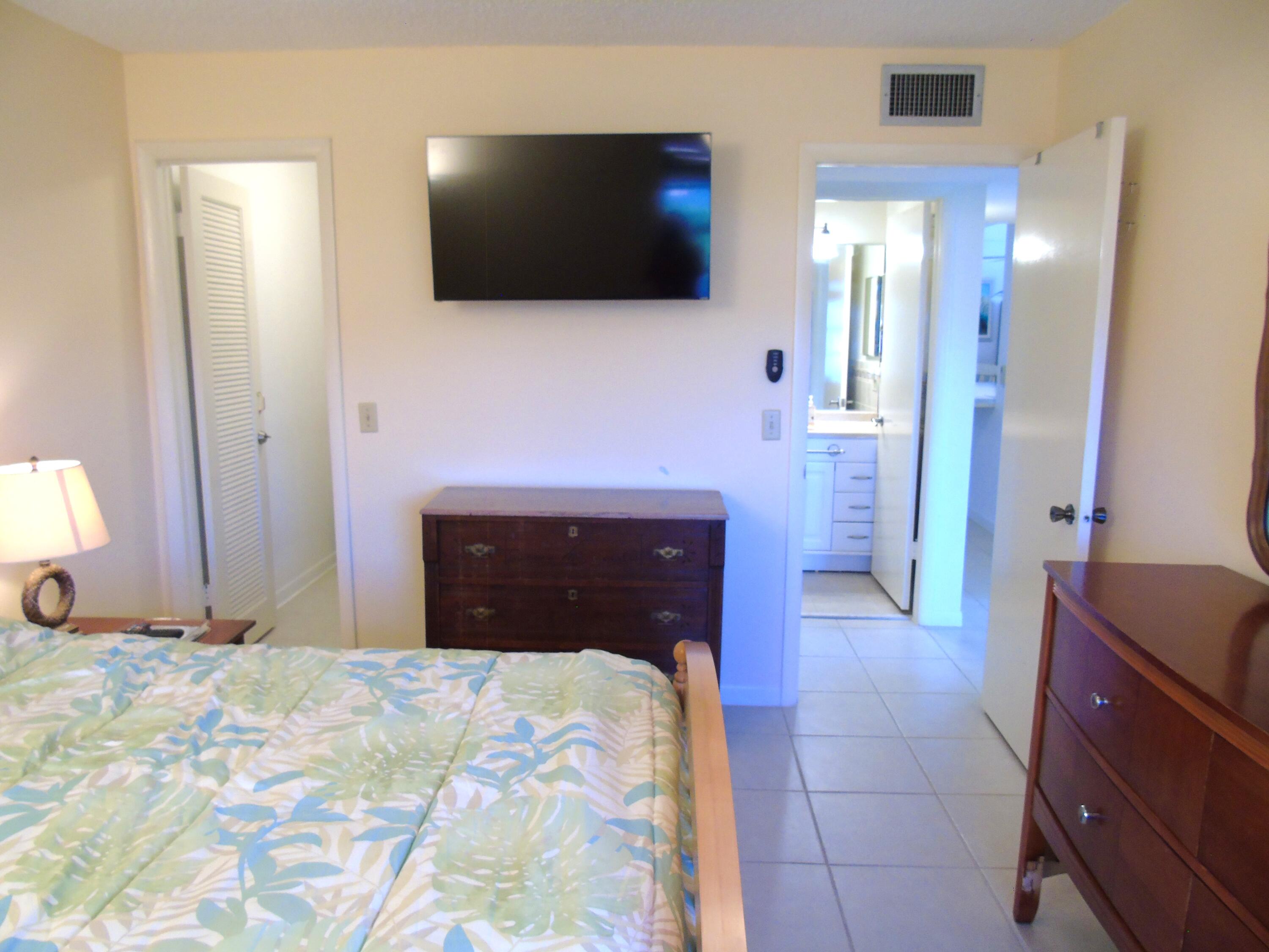 219 Normandy Lane Delray Beach, FL 33484 - Photo 13 of 33 a bedroom with a bed and a flat screen tv
