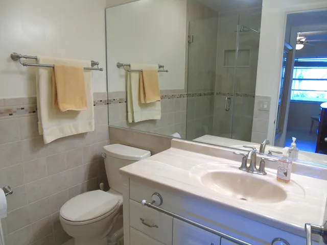 a bathroom with a sink toilet vanity and shower