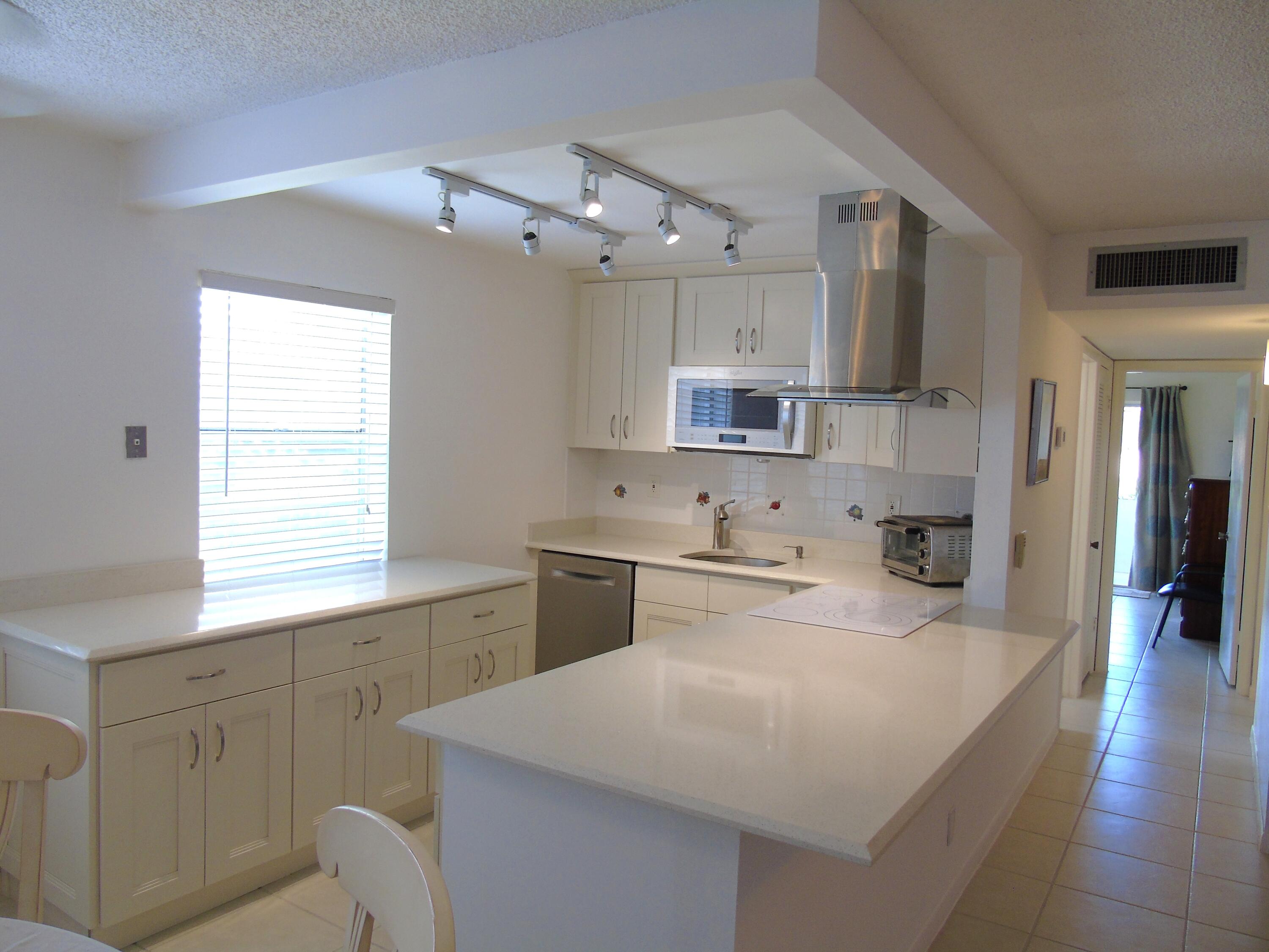 219 Normandy Lane Delray Beach, FL 33484 - Photo 2 of 33 a kitchen with white cabinets appliances and a window