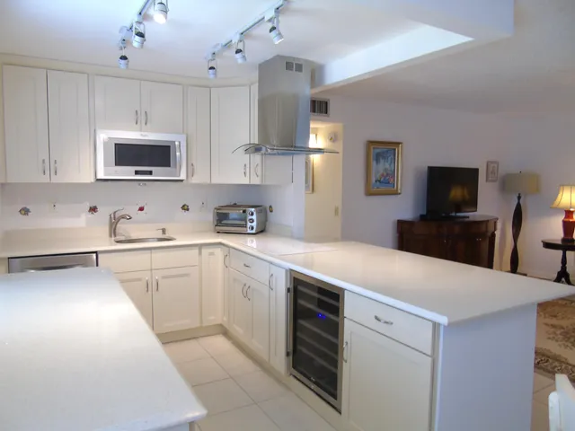 a kitchen with a sink a microwave and cabinets