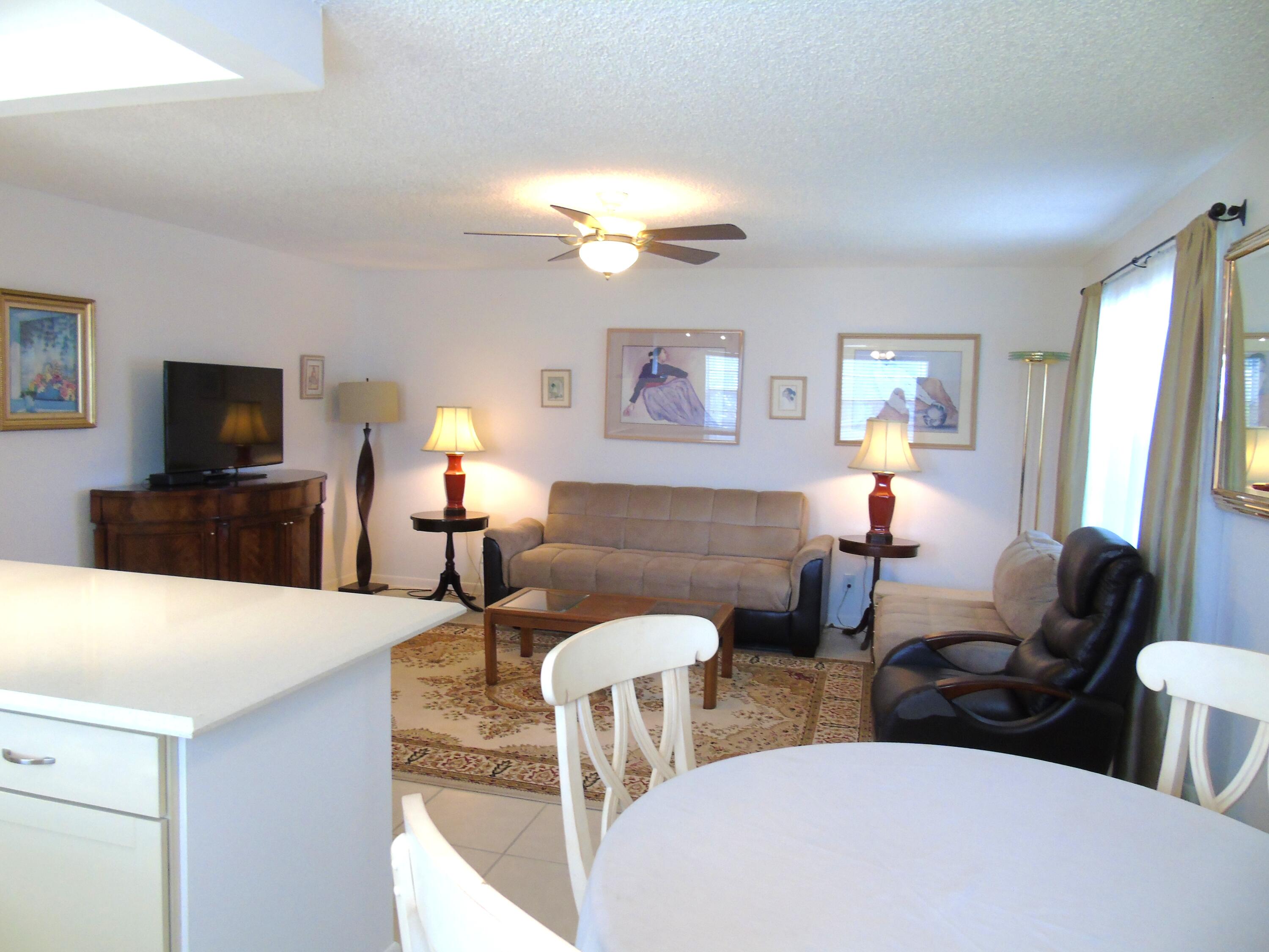 219 Normandy Lane Delray Beach, FL 33484 - Photo 5 of 33 a living room with furniture a fireplace and a flat screen tv