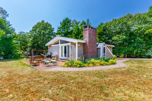 a view of a house with backyard and sitting area