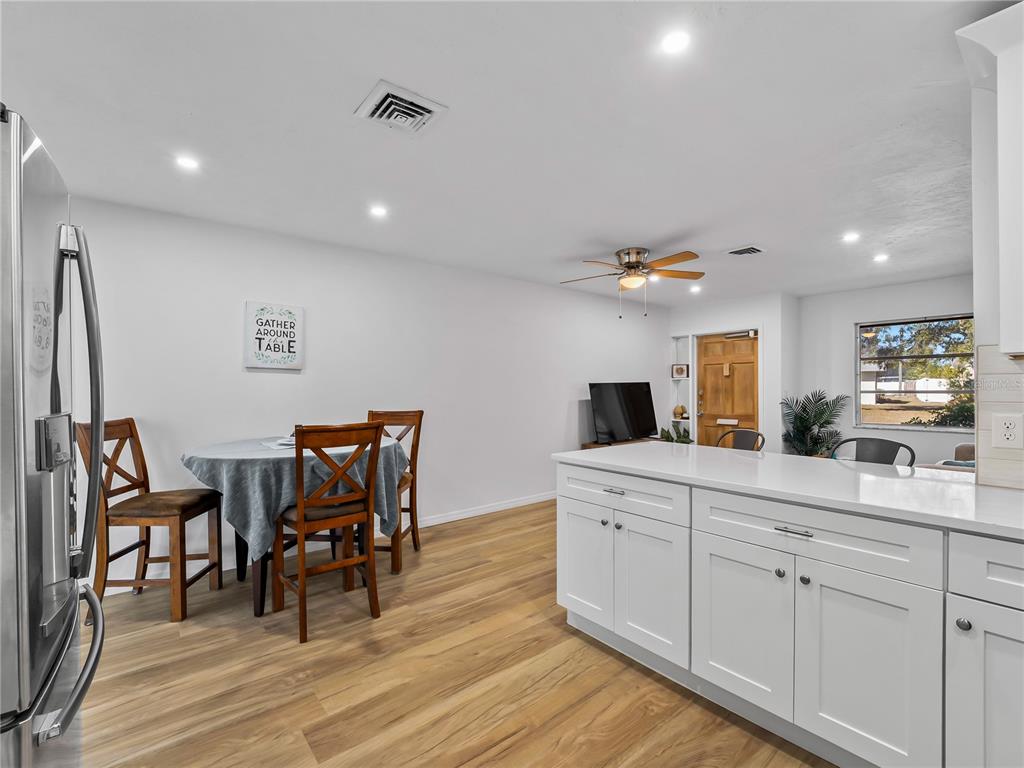 116 The Corso, Unit 116 Venice, FL 34285 - Photo 12 of 36 a kitchen with stainless steel appliances kitchen island granite countertop a dining table chairs and a refrigerator