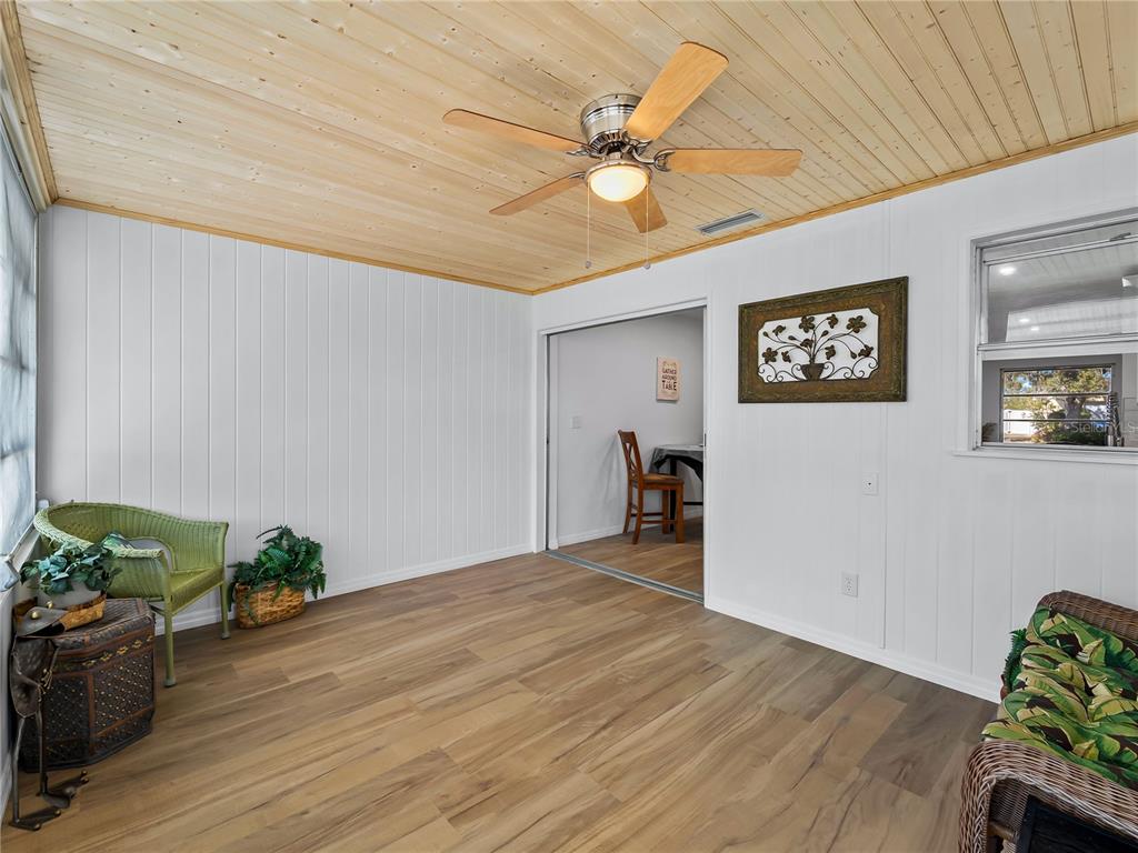 116 The Corso, Unit 116 Venice, FL 34285 - Photo 18 of 36 a view of a livingroom with wooden floor and a ceiling fan