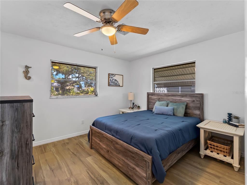 116 The Corso, Unit 116 Venice, FL 34285 - Photo 20 of 36 a bedroom with a bed and a chandelier