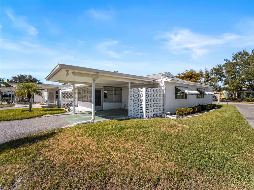 116 The Corso, Unit 116 Venice, FL 34285 - Photo 28 of 36 a view of a house with a big yard and large trees