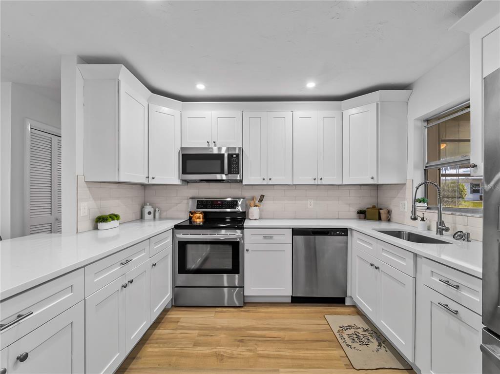 116 The Corso, Unit 116 Venice, FL 34285 - Photo 10 of 36 a kitchen with white cabinets appliances and sink