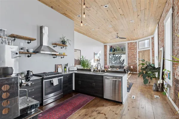 a kitchen with stainless steel appliances granite countertop a stove a sink dishwasher and a refrigerator